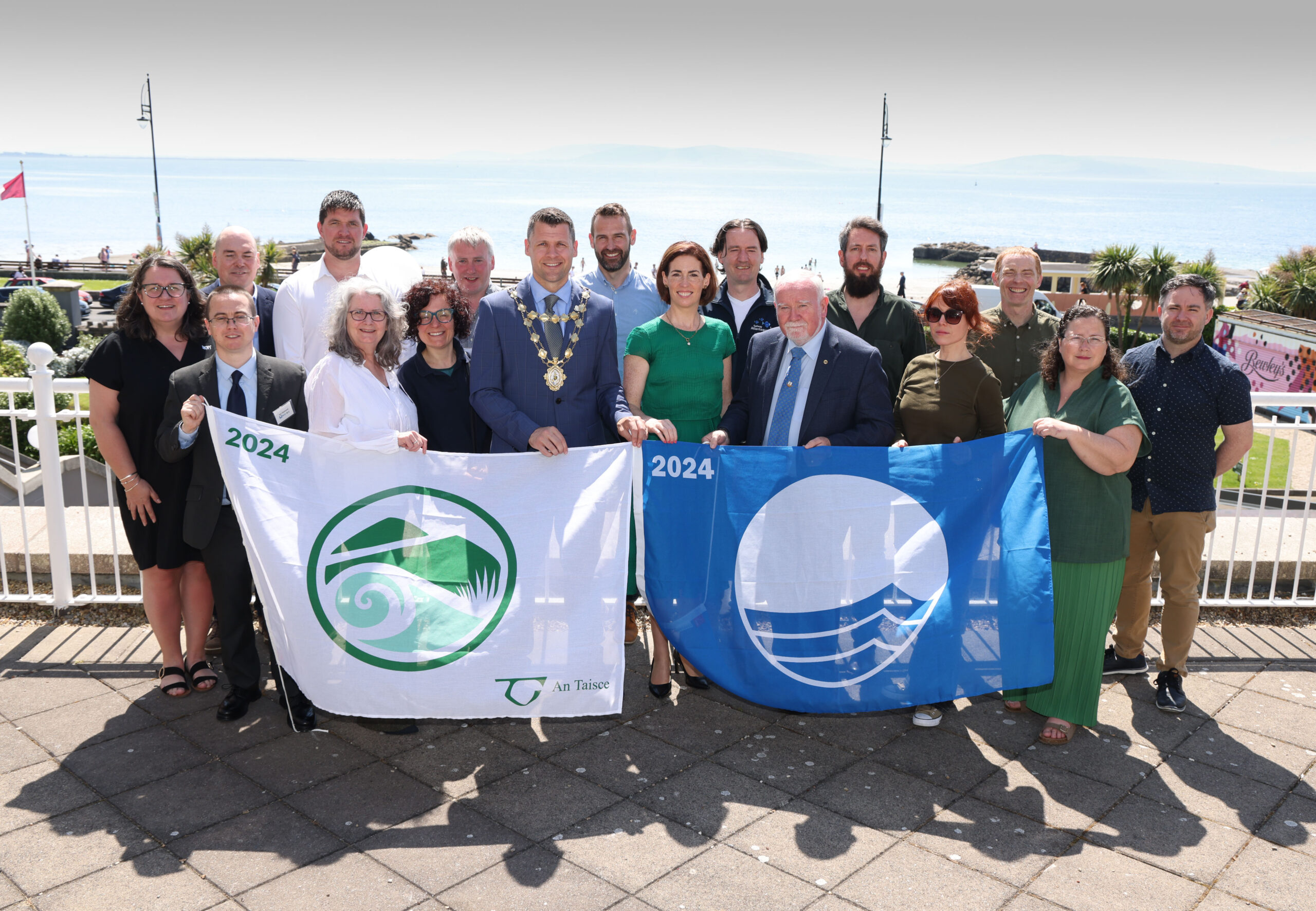 Galway City Awarded The Blue Flag and Green Coast Award for Salthill and Silver Strand for the 2024 bathing season. Photo of representatives of Galway City Council and volunteers with the award flags.